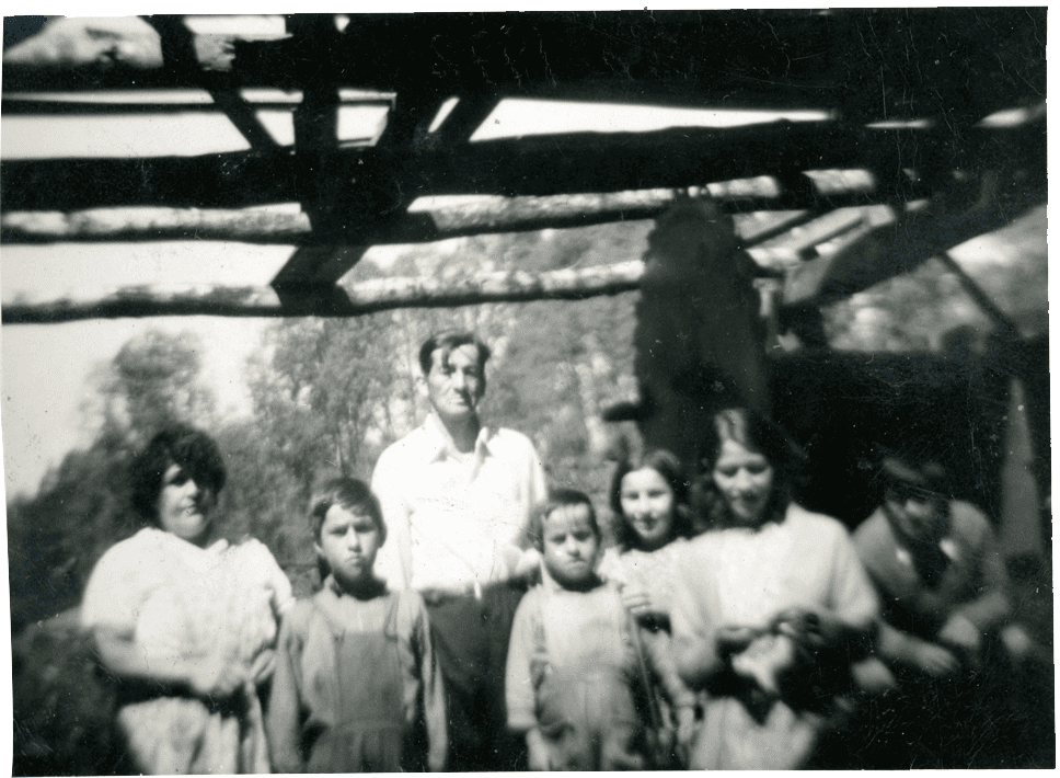 Fotografía de una padre con sus hijas en campo